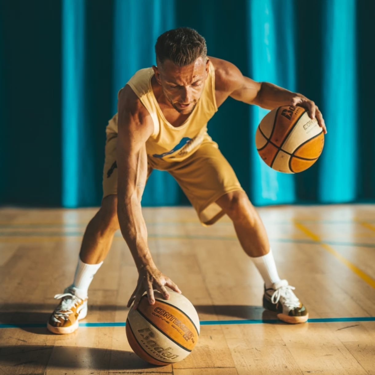 Álvaro Fuentes entrenando manejo de balón con dos balones de baloncesto en una pista de Menorca
